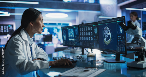 Female Asian Neuroscientist Using Desktop Computer With Human Brain CT Scans In Modern Medical Research Center Laboratory. Professional Doctor Looking At Patient's Brain In 3D Software, Finding Tumors