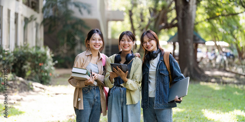 female student is walking to class with friends and stop to look at the camera. back to school concept