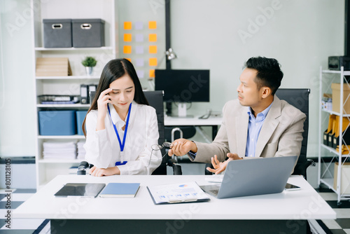 Furious two Asian businesspeople arguing strongly after making a mistake at work in office.