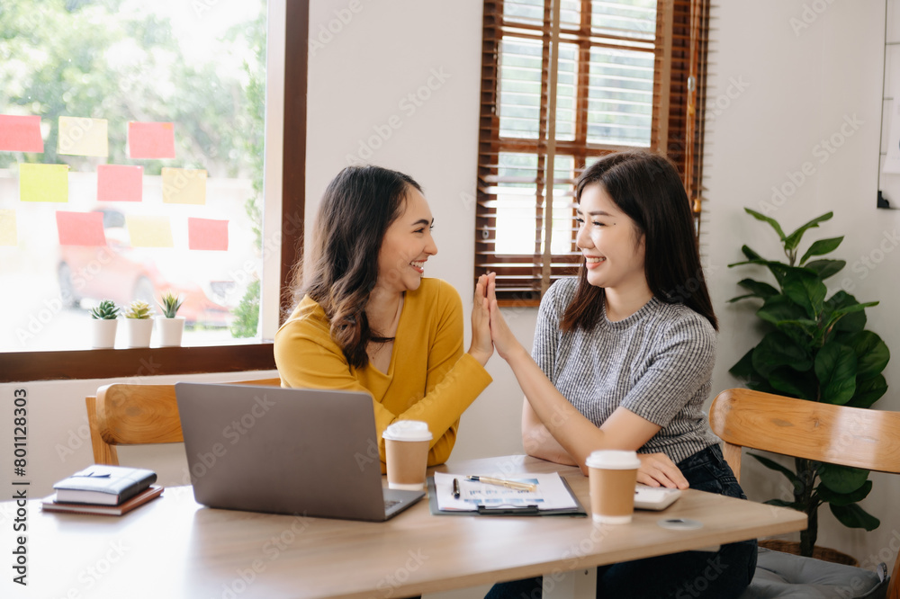 Happy businesspeople while collaborating on a new project in an office. businesspeople using a laptop Happy businesspeople while collaborating on a new project in an office. businesspeople using a laptop