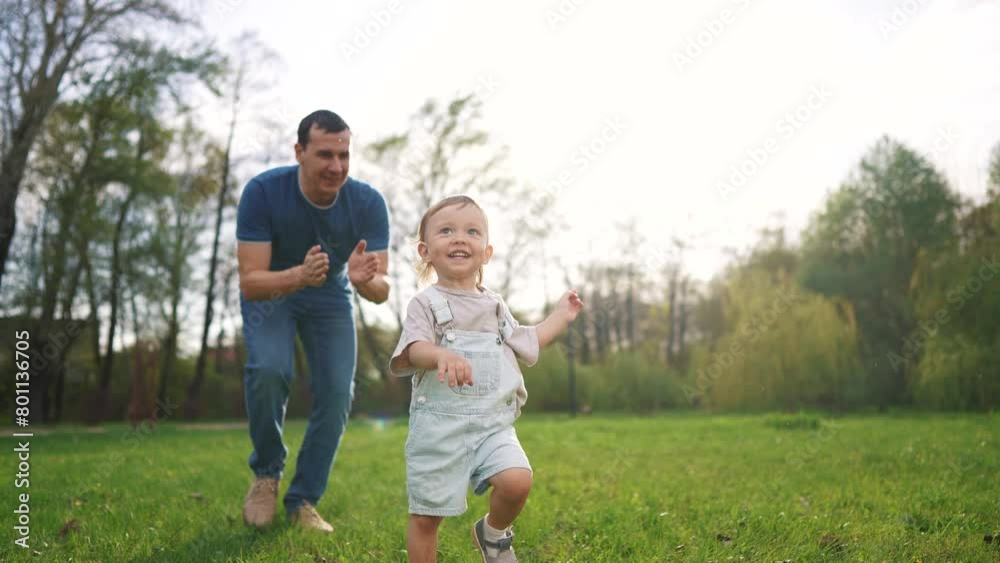 baby toddler and father run play in the park. happy family kid dream concept. baby and father together run play the grass in the summer sunset in the park. father and baby run in lifestyle the park baby toddler and father run play in the park. happy family kid dream concept. baby and father together run play the grass in the summer sunset in the park. father and baby run in lifestyle the park