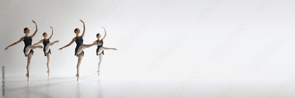 Four ballet dancers, teen girls in black leotards dancing against grey studio background. Synchronization. Ballet, art, dance studio, classical style, youth concept. Banner. Empty space to insert text