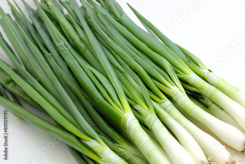green onions. A bunch of fresh green onions lies on a white table, top view vegetable concept