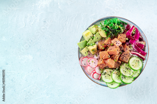 Tuna poke bowl with avocado, cucumbers, wakame, radish, and purple cabbage, shot from above with a place for text