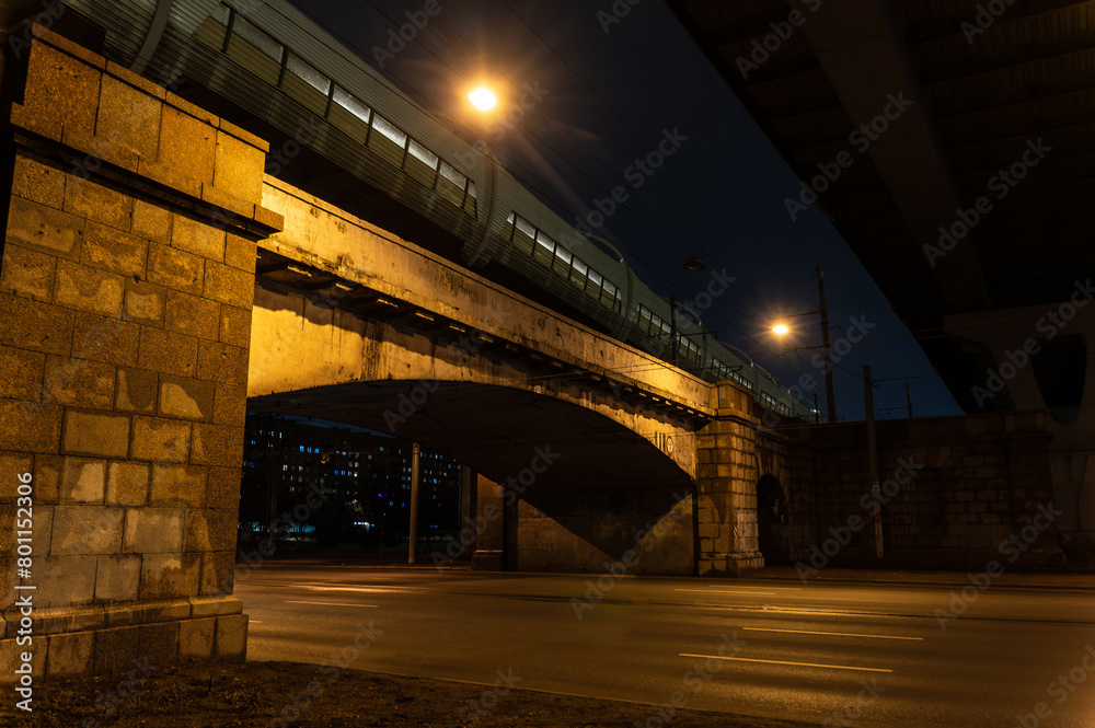 Empty road under bridge at night