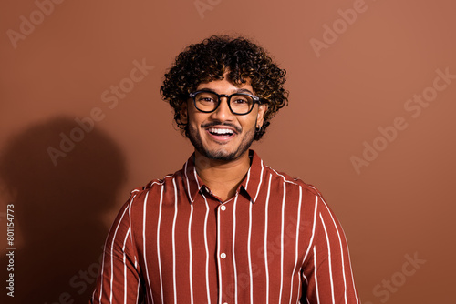 Portrait of nice young man toothy smile wear striped shirt isolated on brown color background photo