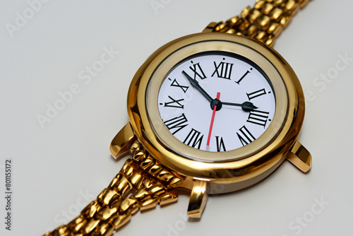 wrist watch. Bright gold wristwatch lies on a white table, close-up top view, style concept
