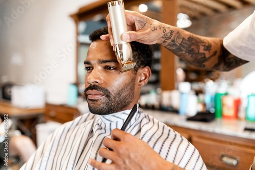 Customer getting a beard trim in a barber shop, small business photo