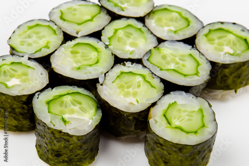rolls with cucumber. small rice rolls with cucumber slices lie on the table, top view, snack concept