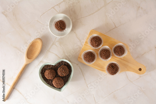 Chocolate truffle ball Brigadeiro brazilian candy and chocolate flakes aerial view clean background