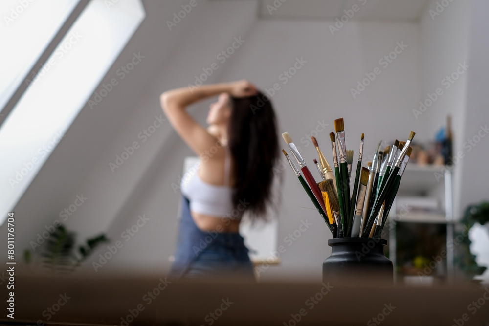 Young female artist paints a picture with oil on canvas in art studio Young female artist paints a picture with oil on canvas in art studio