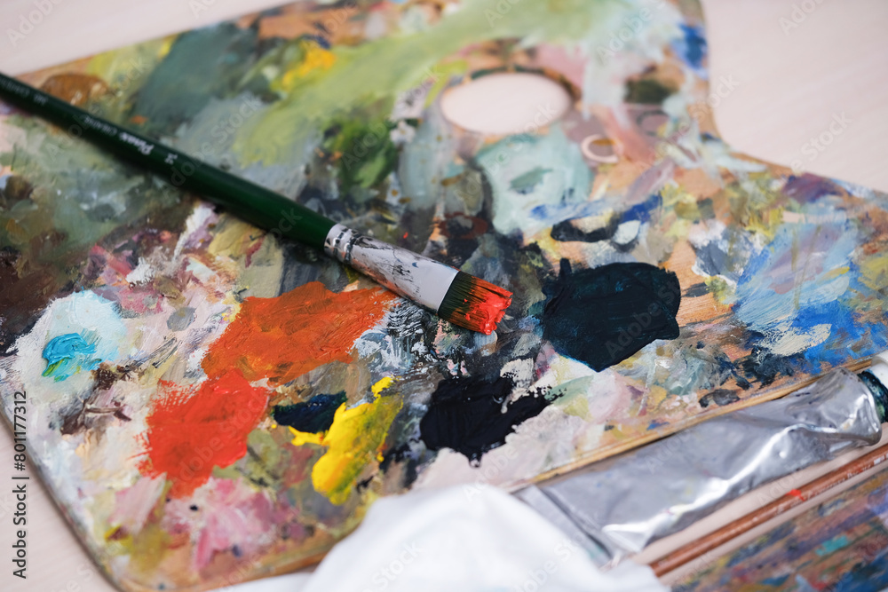 Paint-splattered brushes close up with oil paint in the art studio Paint-splattered brushes close up with oil paint in the art studio
