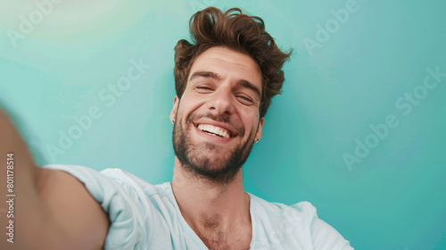 Handsome happy man taking selfie on color background -