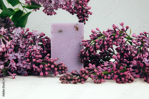 A bar of natural soap with lilac flowers on a concrete background. Cosmetics from natural ingredients, herb. Front view