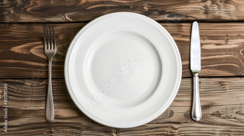 Empty white plate on table with fork and knife