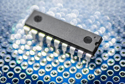 DIP package integrated circuit microchip on a blue printed circuit protoboard or breadboard. © Kuzmick