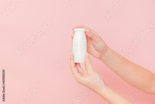 Hand holding bottle of probiotic yogurt for digestive system. Dietary supplements for stomach photo