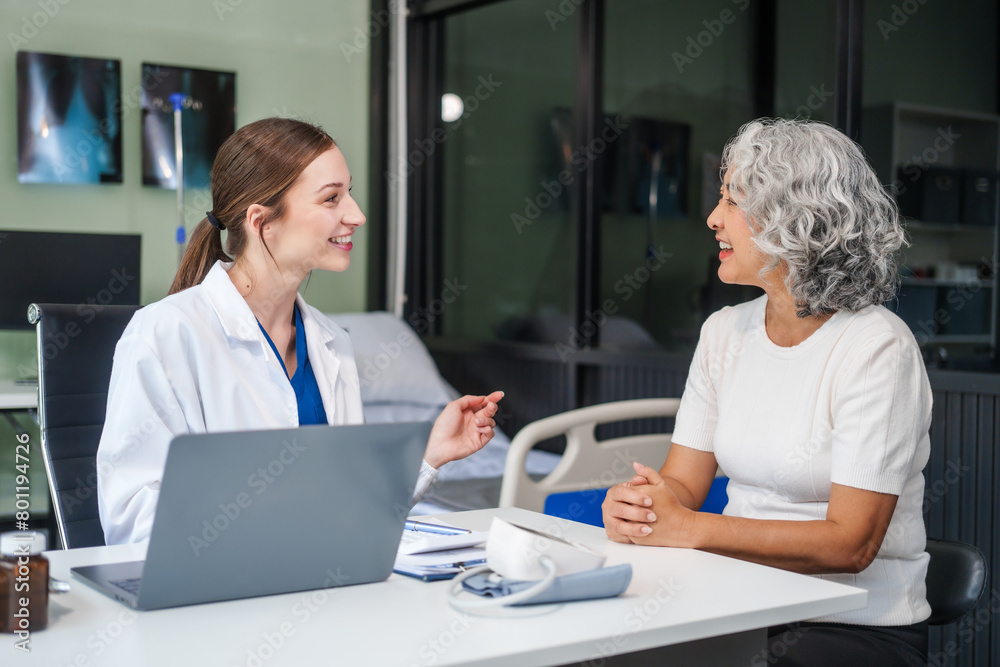 Monthly health check-ups and counseling sessions are provided to an elderly Asian woman by a Caucasian female caregiver, offering support, advice, and motivation.