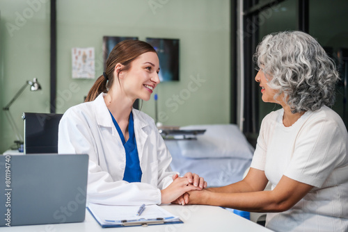 Monthly health check-ups and counseling sessions are provided to an elderly Asian woman by a Caucasian female caregiver, offering support, advice, and motivation.