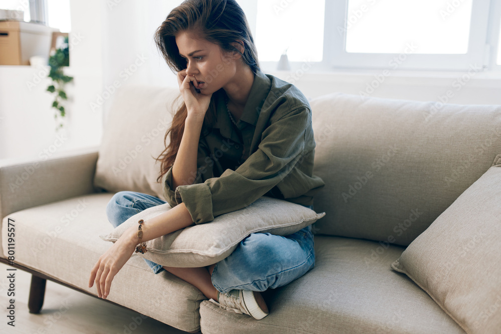 Lonely Woman in Mental Health Crisis, Suffering from Depression and Anxiety, Sitting on Couch at Home, Expressing Sadness and Despair. Lonely Woman in Mental Health Crisis, Suffering from Depression and Anxiety, Sitting on Couch at Home, Expressing Sadness and Despair.