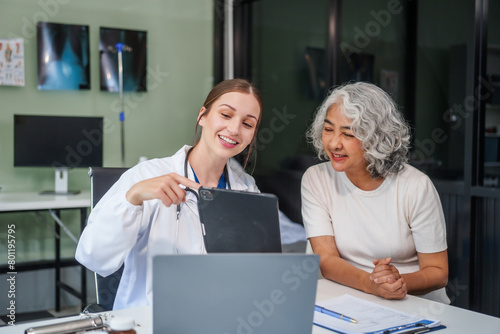 Monthly health check-ups and counseling sessions are provided to an elderly Asian woman by a Caucasian female caregiver, offering support, advice, and motivation. photo