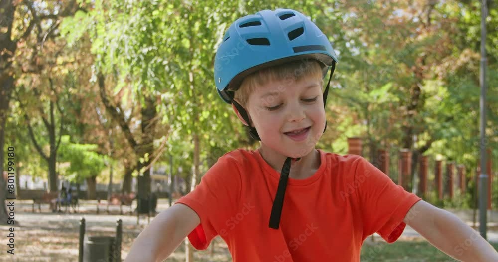 Joyful boy in helmet rings bell on handlebar gearing up for riding in city park. Preschooler eagerly awaits journey on bicycle on summer day Joyful boy in helmet rings bell on handlebar gearing up for riding in city park. Preschooler eagerly awaits journey on bicycle on summer day