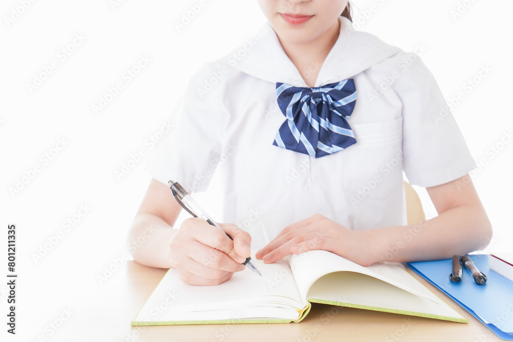 机で勉強をする制服姿の女子学生