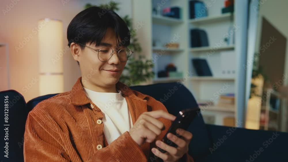 Asian man actively using smartphone apps for social networking, communication