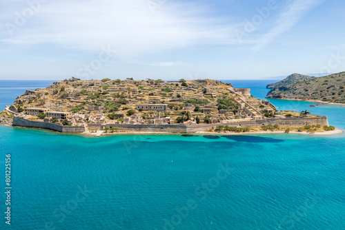 Aerial drone view of Spinalonga island with calm sea. Old venetian fortress island and former leper colony.