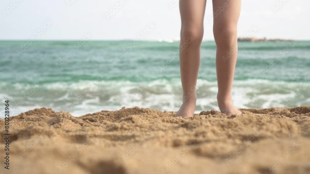 Happy child girl dancing on the beach against the background of the sea, slow motion, close-up Happy child girl dancing on the beach against the background of the sea, slow motion, close-up