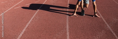 Man getting ready to take off on the running track photo