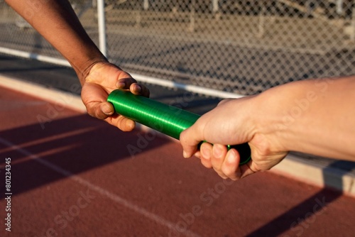 Картината върху платно Team mate relaying the baton to another athlete