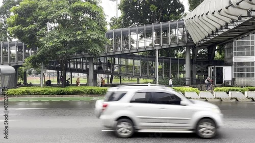 Jakarta, Indonesia - March 10th, 2024 - Gelora Bung Karno halte transjakarta bus transit public transportation area side walk and road after rain isolated on horizontal ratio template. photo
