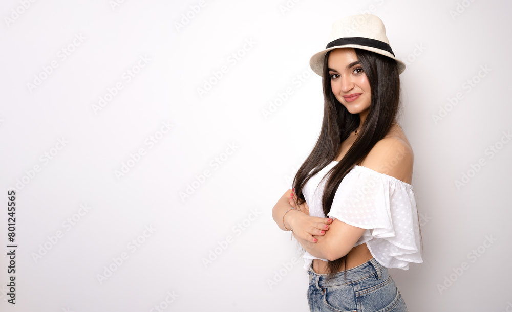 Young woman wearing straw hat with arms folded standing isolated over white background. Young woman wearing straw hat with arms folded standing isolated over white background.