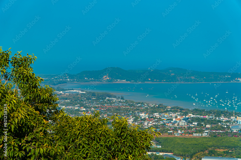 The Big Buddha Phuket viewpoint shows views of the land, the beach, the surrounding boats and the island which is not too far away. Panoramic beauty with a blue sky background during the day