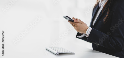 2FA login concept. Businesswoman working on laptop logging in on smartphone and modern device. Businesswoman doing paperwork in the office.