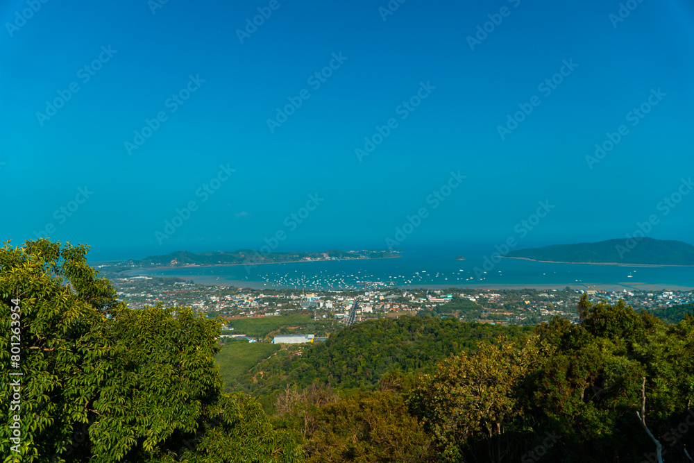 The Big Buddha Phuket viewpoint shows views of the land, the beach, the surrounding boats and the island which is not too far away. Panoramic beauty with a blue sky background during the day
