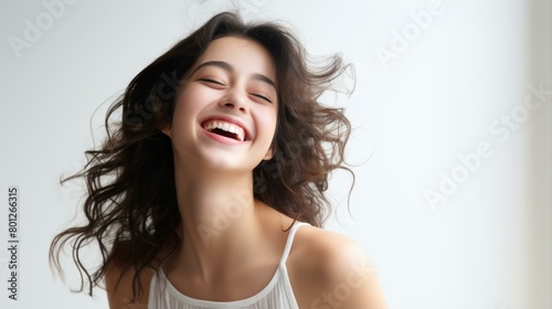 Portrait of a beautiful young woman with long brown hair smiling happily