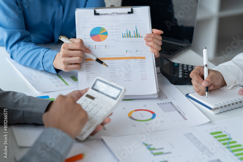 close-up hands image, Professional Asian male and female financial consultant or analyst working with them team, brainstorming and analyzing financial data on the report together in the office