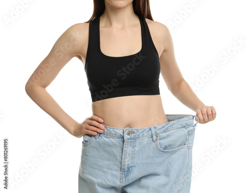 Woman in big jeans showing her slim body on white background, closeup