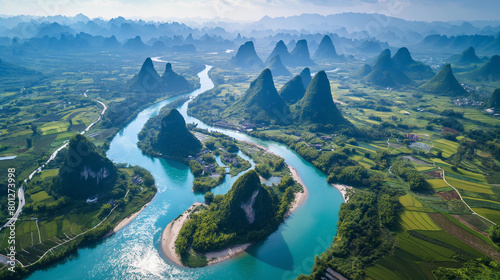  an aerial shot of the Li River in China. The river winds its way through the green and misty mountains. There are small villages and boats on the river. photo