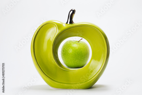 Natural green apple inside a ceramic apple on white background photo