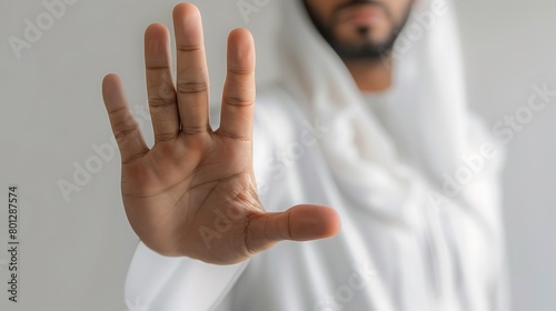 Arabic man wearing a Saudi bisht and traditional white shirt, hand gesture: opening 5 fingers to the front. photo