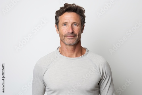 Portrait of a content man in his 40s showing off a thermal merino wool top isolated in white background