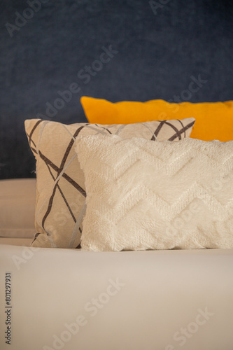 Colorful cushions on bed in illuminated room.