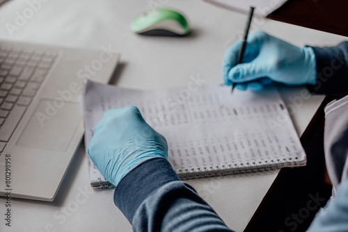 professional working with numerical data. Clad in blue gloves, person carefully logs information, highlighting precision necessary in scientific or clinical data analysis