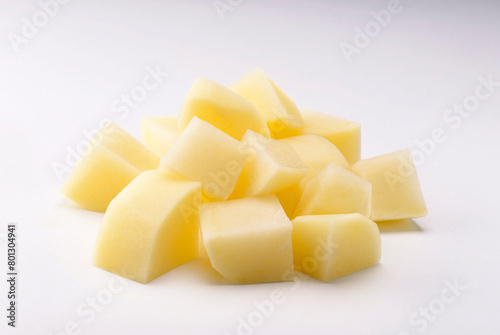 raw potato cut into square pieces on white background
