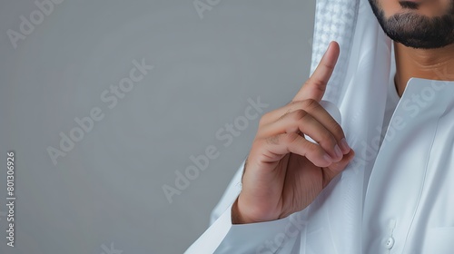 Arabic man wearing a Saudi bisht and traditional white shirt, hand gesture: thumb and index finger. photo
