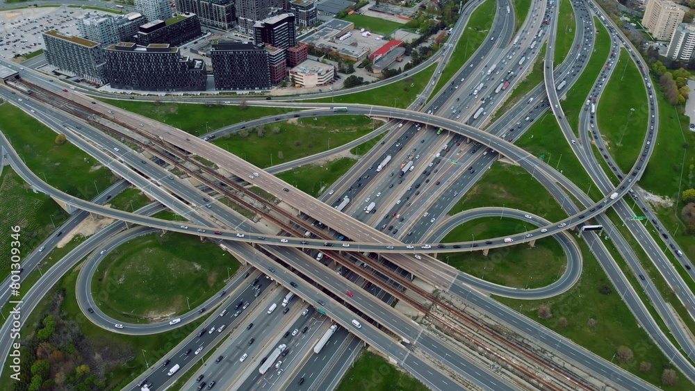 Busy urban junctions teem with cars, drone hovers over impressive infrastructure layout. Cars stream along elevated expressways, drone captures intricate design of urban transport network Motorway.