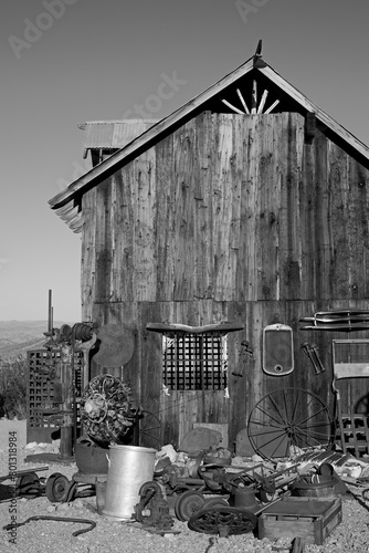 USA, Nevada. Village fantôme abandonné depuis 1940. Vielle baraque, atelier de bricolage, remise à outils agricoles rouillés. Image noir et blanc.